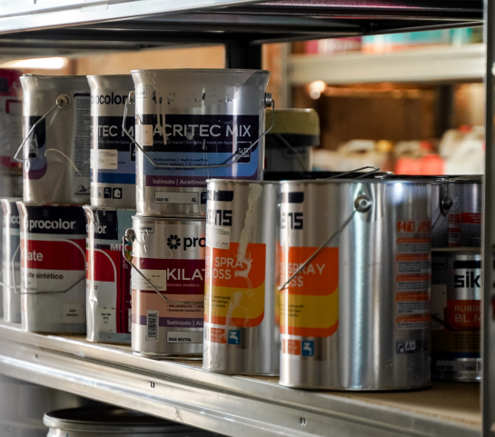 Latas de pintura profesional en estantería