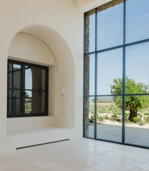 Interior luminoso tras trabajo de pintura de interiores realizado por pintores en Mallorca con ventanal y arco